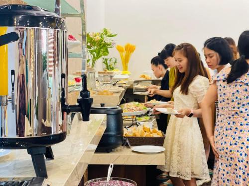 a group of people preparing food in a buffet line at Ha Long Seasun Hotel in Ha Long