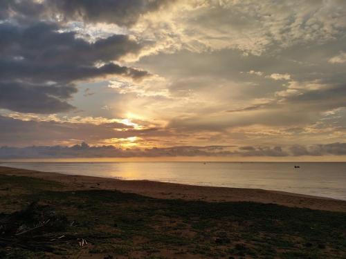 a sunset on a beach with the ocean at Helios Beach Resort in Tangalle