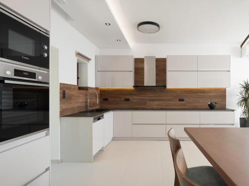 a kitchen with white cabinets and a wooden counter top at Anema Villa, a picture-perfect summer escape,By ThinkVilla in Roumelí