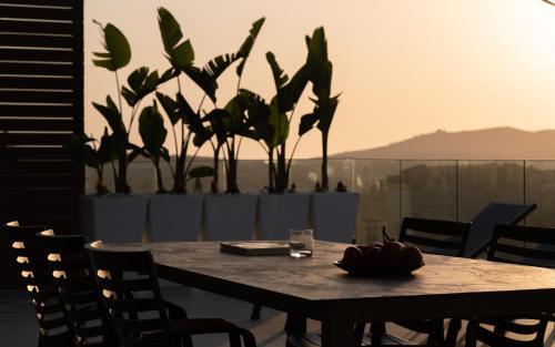 a wooden table with chairs and a bowl of fruit on it at Anema Villa, a picture-perfect summer escape,By ThinkVilla in Roumelí