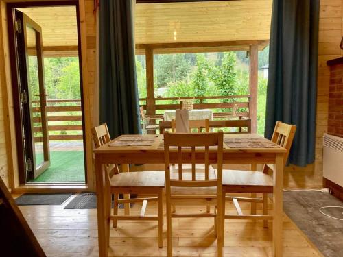 a dining room with a wooden table and chairs at Tiny house Casa Axa in Pîrîu Cîrjei