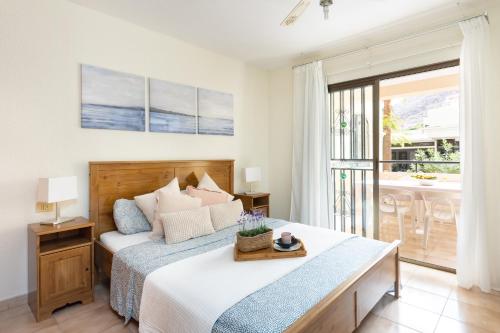 a bedroom with a bed and a balcony at Home2Book Charming Castle Harbour Los Cristianos in Los Cristianos