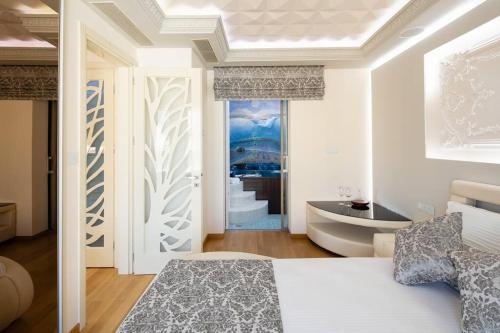 a bedroom with a bed and a tub and a sink at Ni President Suite, DeMaNi President Suites in Sitia