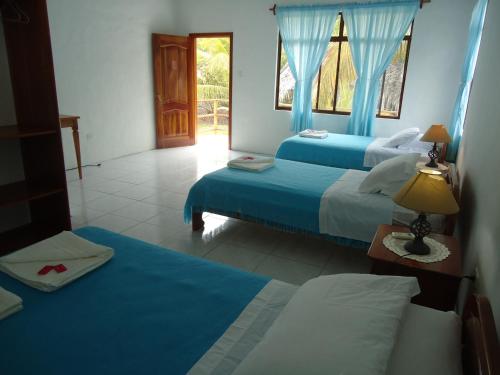 Habitación de hotel con 2 camas y ventana en Cartago Bay en Puerto Villamil