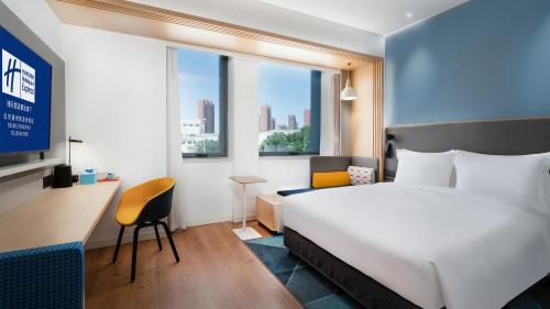 a hotel room with a bed and a desk and a window at Holiday Inn Express Beijing Tongzhou Tourism Zone, an IHG Hotel in Beijing