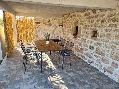 a wooden table and chairs on a patio at Holiday Home Nena in Drniš