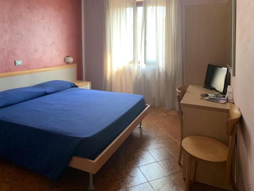 sypialnia z niebieskim łóżkiem i biurkiem z komputerem w obiekcie Aquila Nera Di Tony w mieście Ivrea