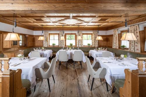 a dining room with white tables and chairs at Der Böglerhof - pure nature spa resort in Alpbach