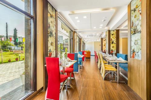 a restaurant with red and blue chairs and tables at The Vaishnodevi Sarovar Portico in Katra
