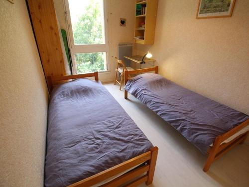 deux lits dans une chambre avec une fenêtre dans l'établissement Luchon - T2 avec balcon, animaux admis, parking - FR-1-313-146, à Luchon