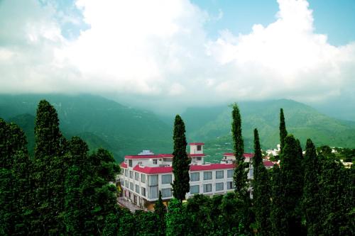 a white building with a red roof on a mountain at The Vaishnodevi Sarovar Portico in Katra