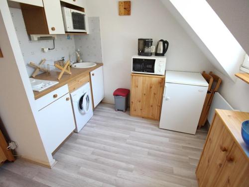 une cuisine avec un réfrigérateur blanc et un évier dans l'établissement Bagnères-de-Luchon : Duplex calme 4 pers, balcon, parking - FR-1-313-143, à Luchon