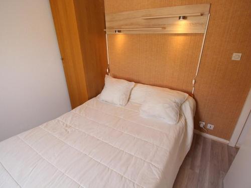 - une petite chambre avec un lit blanc dans l'établissement Bagnères-de-Luchon : Duplex calme 4 pers, balcon, parking - FR-1-313-143, à Luchon