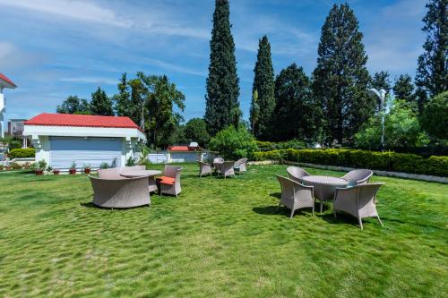 a group of tables and chairs in the grass at The Vaishnodevi Sarovar Portico in Katra