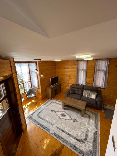 a living room with a couch and a tv at Konačište Osmica in Mokra Gora