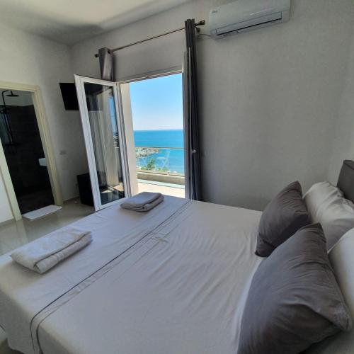 a large white bed with a view of the ocean at Hotel 33 in Shëngjin