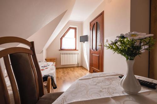a room with a table with a vase of flowers on it at Pokoje u Borzana in Biały Dunajec