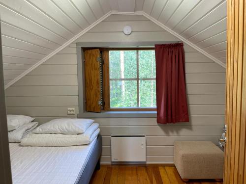 Bett in einem Zimmer mit Fenster in der Unterkunft Hillside Cottage in Ivalo
