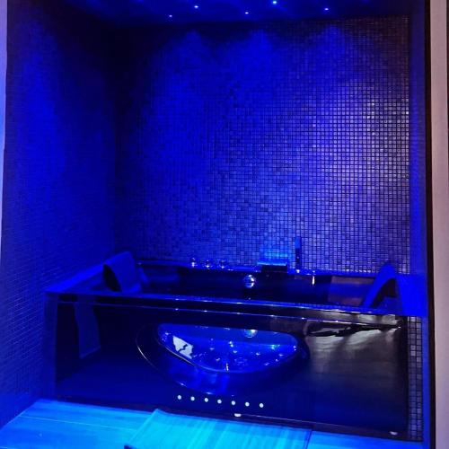a blue bathroom with a tub with a blue light at Dolce&casanova in Farinole