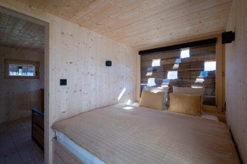 a bed in a small room with a window at ALTYPIC Mayen d'exception en Valais in Bruson