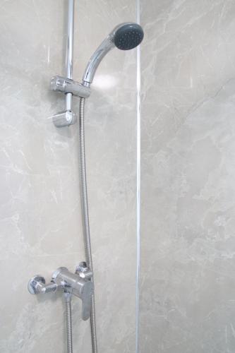 a shower with a shower head in a bathroom at Aria Lodging Inverness in Inverness