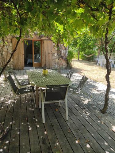 une table et des chaises sur une terrasse en bois dans l'établissement Les bergeries de Montestremo, à Manso