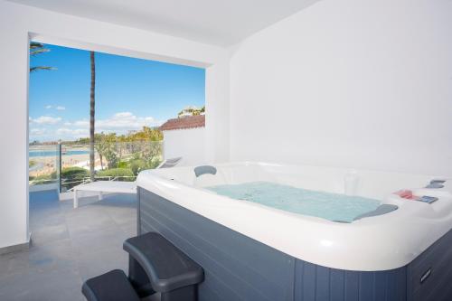 a hot tub in a room with a view of the ocean at B51 Executive Flats Marbella in Marbella