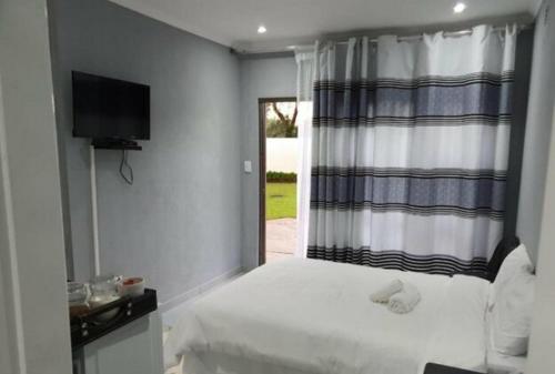 a bedroom with a white bed and a window at Zea 85 BnB in Vereeniging