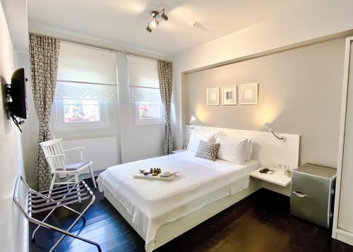 a hotel room with a white bed and a chair at 19 Oda Bozcaada in Çanakkale