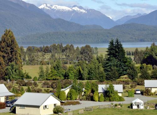 an aerial view of a farm with mountains in the background at Blue Thistle Cottages in Te Anau