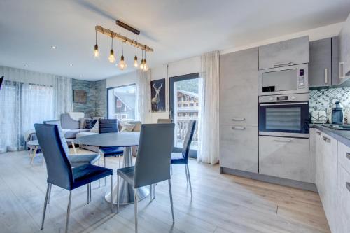 une cuisine et une salle à manger avec une table et des chaises dans l'établissement Edelweiss Cosy, à Morzine