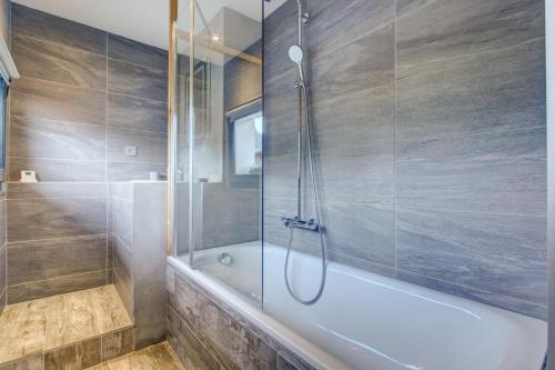 a bathroom with a shower and a bath tub at Edelweiss Cosy in Morzine
