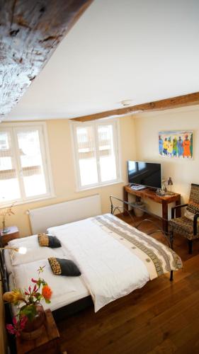 a bedroom with a bed and a desk and a television at Bed & Breakfast SahaRa in Lüneburg