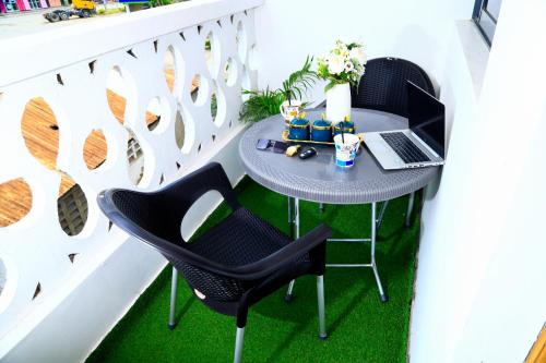 een kleine tafel met 2 stoelen en een laptop op een balkon bij Royal Haven A1 Apartment in Mombasa - Bamburi, 50" HDTV, WiFi, 6 mins to Beach in Mombasa