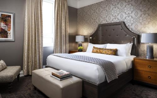 a hotel room with a large bed and a chair at Fairmont Palliser in Calgary