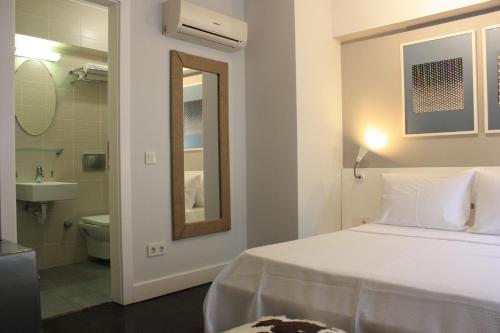 a white bedroom with a bed and a bathroom at 19 Oda Bozcaada in Çanakkale
