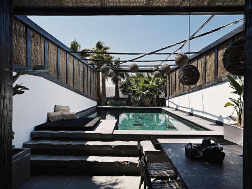 a house with a swimming pool and stairs at Myconian O, a Member of Design Hotels in Ornos