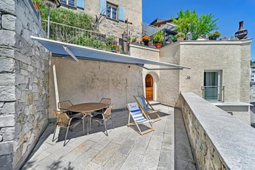 a patio with a table and chairs and a building at Abitaziun Sur Ovel - St Moritz "LOGA ELEGANCE APARTMENT" in St. Moritz