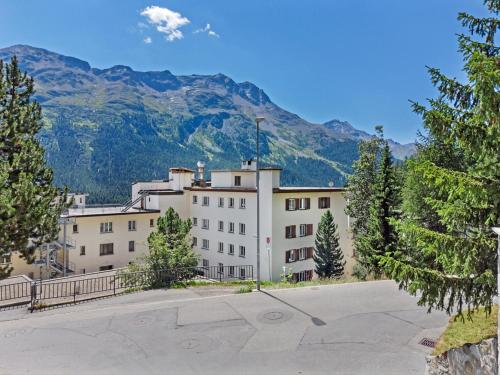 a large white building with mountains in the background at Abitaziun Sur Ovel - St Moritz "LOGA ELEGANCE APARTMENT" in St. Moritz