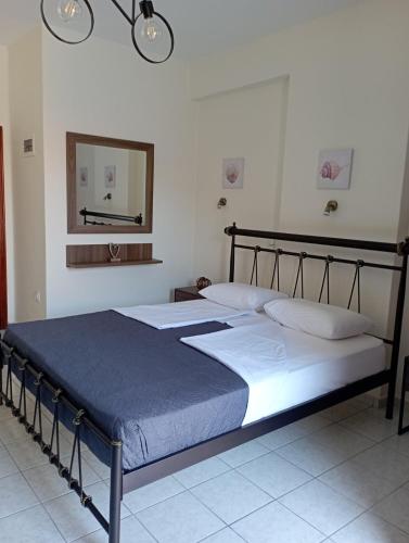 a bedroom with a large bed with a blue blanket at Sofirene I in Batsi