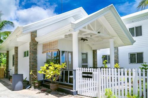 a white fence in front of a white house at Grande Villa in Panglao