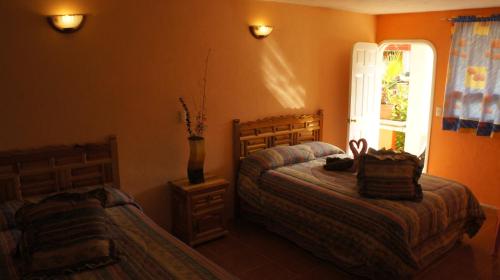 a bedroom with two beds and a window at Hotel Posada Tolteca in Tula de Allende