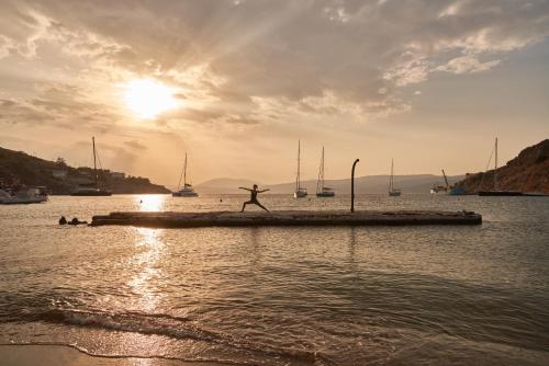a person walking on a dock in the water at Mandraki Beach Resort in Mandraki