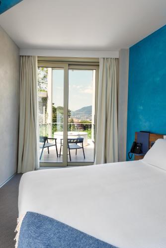 a bedroom with a bed and a view of a patio at Carrick Hotel Camogli Portofino Coast in Camogli