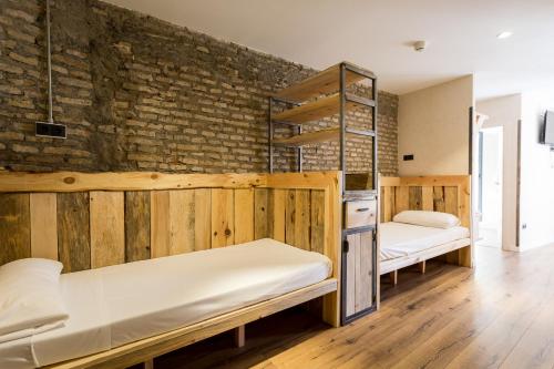 a room with two bunk beds and a brick wall at Black Swan the Penthouse in Seville