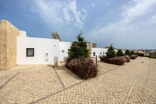 a white building with plants in front of it at Villa Sagres Surf in Sagres