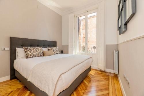 a bedroom with a large bed and a window at Madrid 1915 Private Suites in Madrid