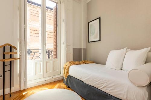 a bedroom with a bed and a window at Madrid 1915 Private Suites in Madrid