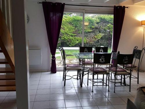 une salle à manger avec une table et des chaises et une fenêtre dans l'établissement Maison 90m² avec jardin, proche commerces et plages, équipée et idéale famille. - FR-1-494-120, à Vaux-sur-Mer