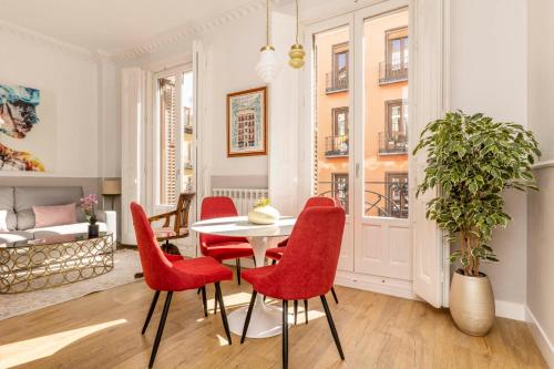 a dining room with red chairs and a table at Madrid 1915 Private Suites in Madrid